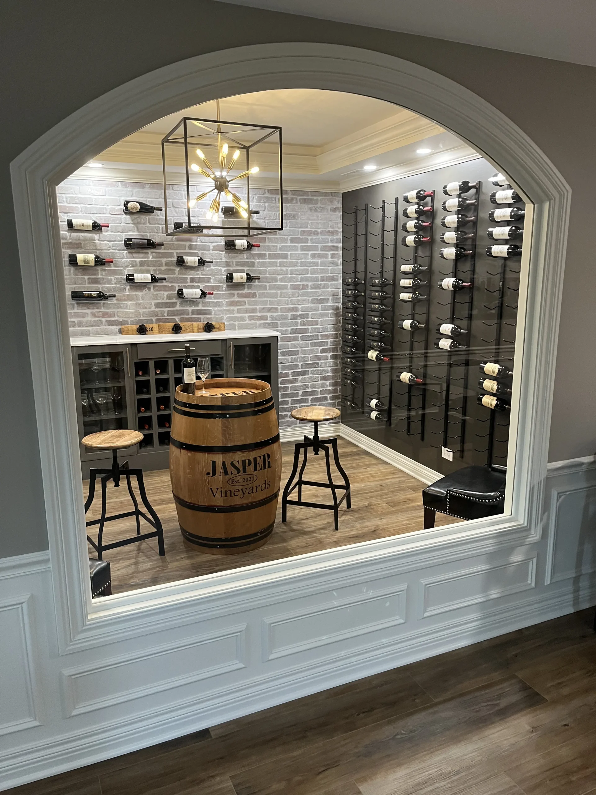 Custom wine cellar with arched opening, brick wall, and whisky barrel