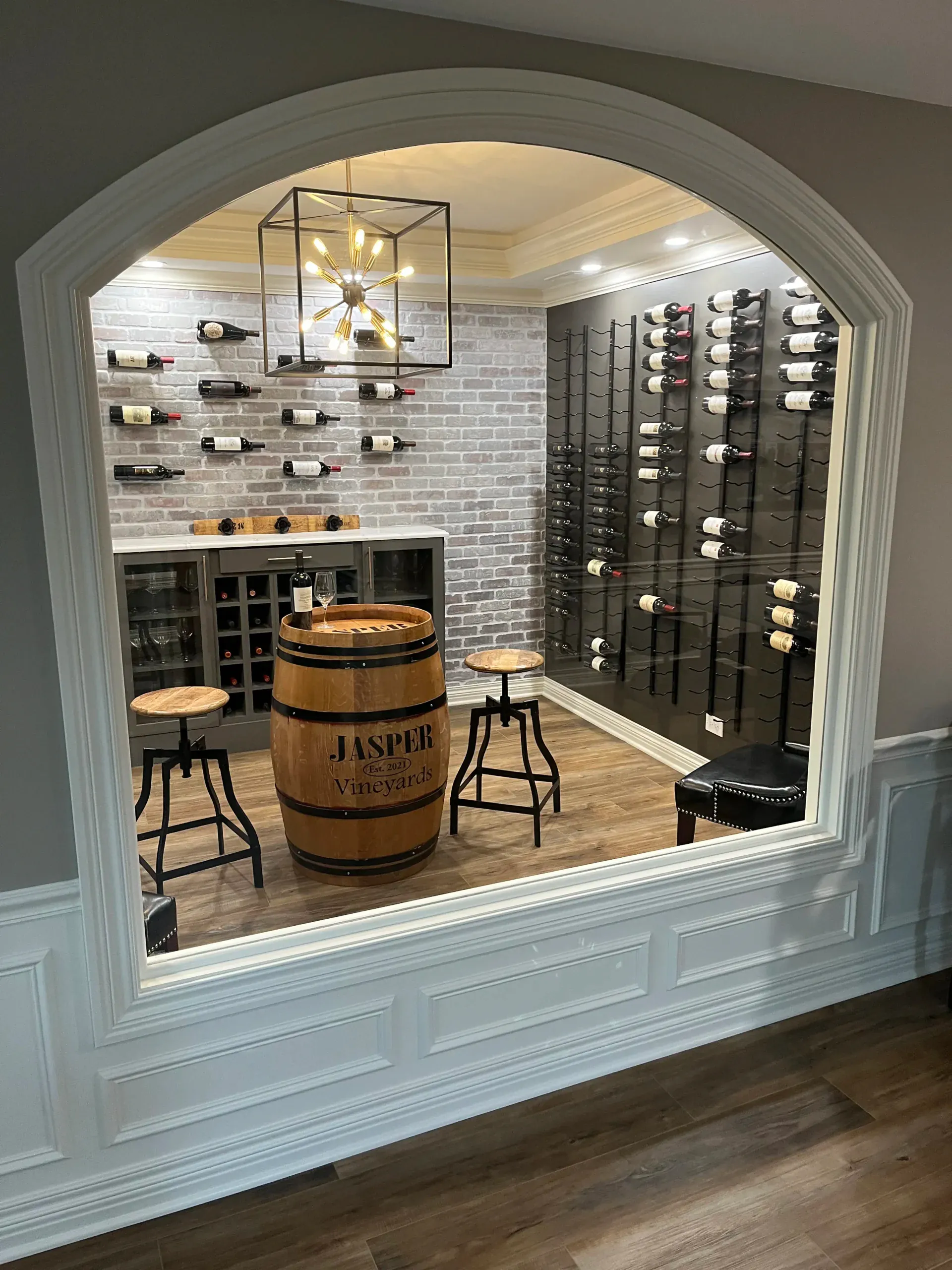 Custom wine cellar with arched opening, brick wall, and whisky barrel