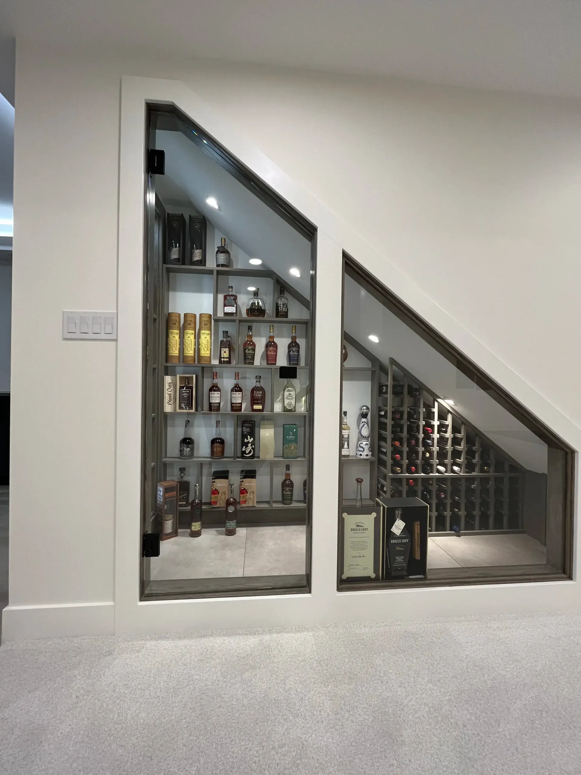 Under-stair whisky and wine display with arched glass