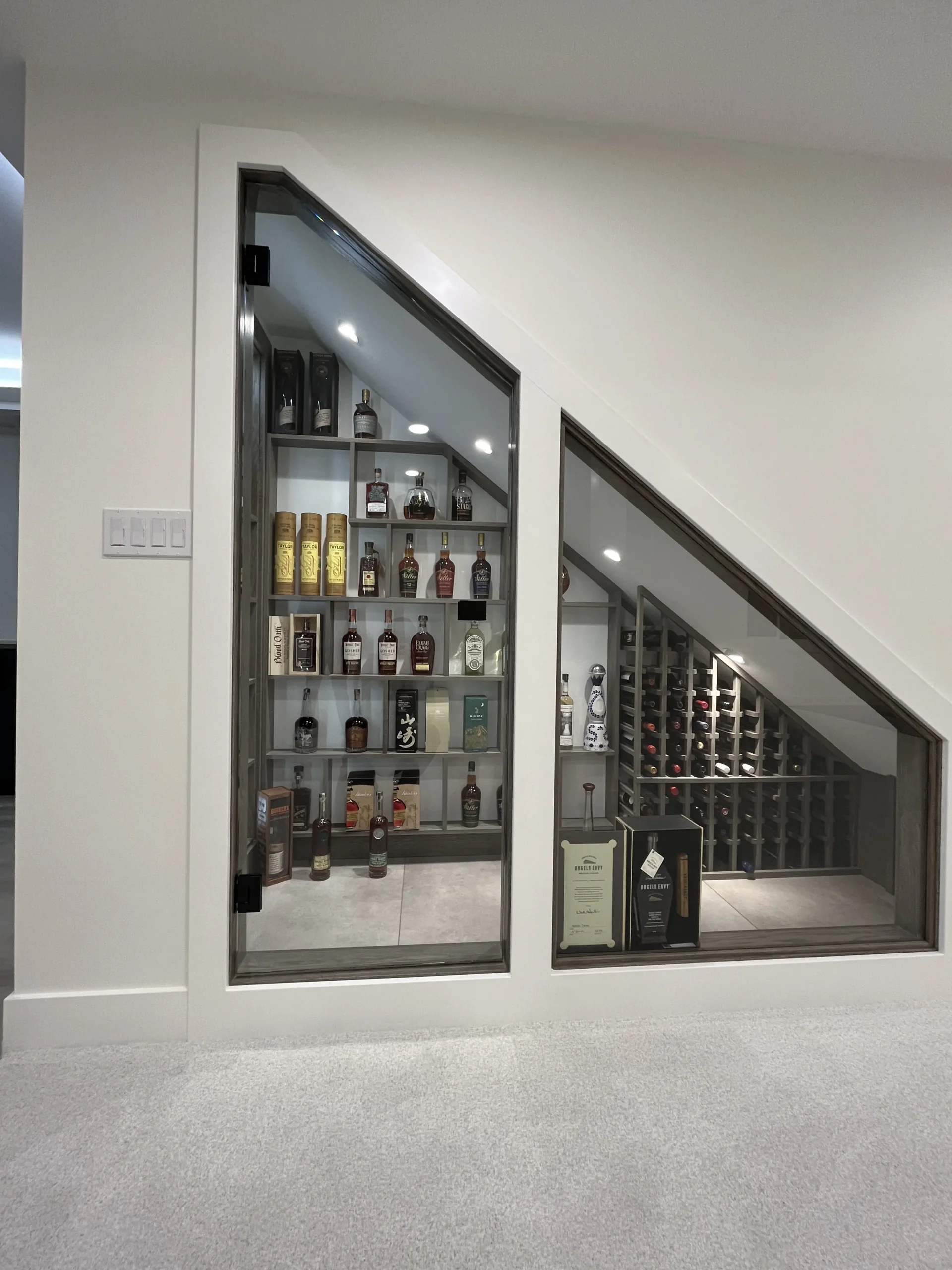 Under-stair whisky and wine display with arched glass